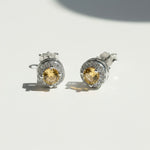 Silver stud earrings with platinum plating and yellow birthstone center, surrounded by sparkling CZ halo.