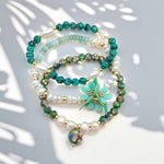 Set of beaded bracelets with green and white stones on a light background