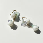 Floral earrings with white and light green flowers on a white background