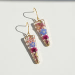 Pair of floral earrings with gold hooks on a white background