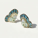 Pair of earrings with butterfly-like design and floral elements on a light background