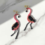 Flamingo-shaped earrings on a marble surface