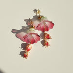 Floral earrings with pink and gold details on a light background