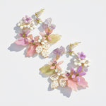 Pair of floral earrings with pastel colors on a light background