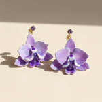 Purple orchid earrings on a beige background
