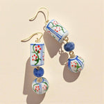 Colorful ceramic earrings with blue beads on a beige background