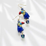 Toucan-shaped earrings with blue and gold details on a white background