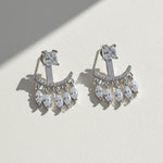 Pair of silver chandelier earrings with clear gemstones on a light background