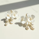 Pearl and white flower earrings on a light background