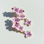 Floral earrings with pink and purple flowers on a light background