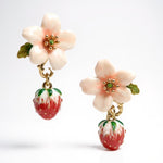 Floral and strawberry-themed earrings on a white background