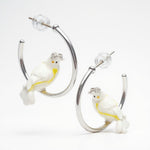 Earrings with white cockatoo figures on a white background