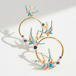 Colorful hoop earrings with floral designs on a light gray background