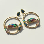 Gold earrings with colorful chameleon designs on a light background