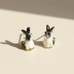 Pair of rabbit-shaped earrings on a beige background