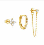 Gold jewelry set including earrings and a chain on a white background