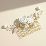 White floral hair comb with sunlight and shadow, gold leaves detail.