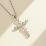 Sparkling VVS1 moissanite cross pendant in platinum-plated silver displayed under warm sunlight
