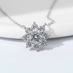 Close-up of floral halo pendant with 1ct centre moissanite and halo stones on platinum plated sterling silver.