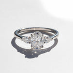 Close-up of 1.5ct oval moissanite three-stone ring in sterling silver.