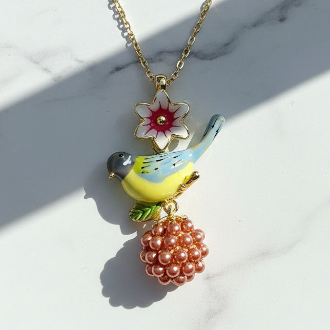 Necklace with a bird and flower pendant on a marble surface
