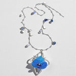 Necklace with blue flower pendant on a white background