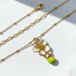 Gold chain necklace with a floral pendant on a white background