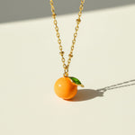Necklace with an orange pendant on a light background