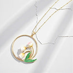 Gold necklace with a floral pendant on a light gray background