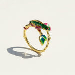 Gold ring with a colorful lizard design on a white background