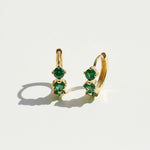 Gold-plated hoop earrings with three green birthstones in graduated sizes, elegant minimalist May birthstone design.