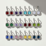 12 birthstone dangle earrings set with cushion-cut halo stones for each month, platinum-plated silver leverback design.