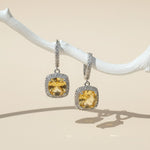 Citrine birthstone dangle earrings with cushion-cut yellow stones and halo CZ, platinum-plated silver leverback design.
