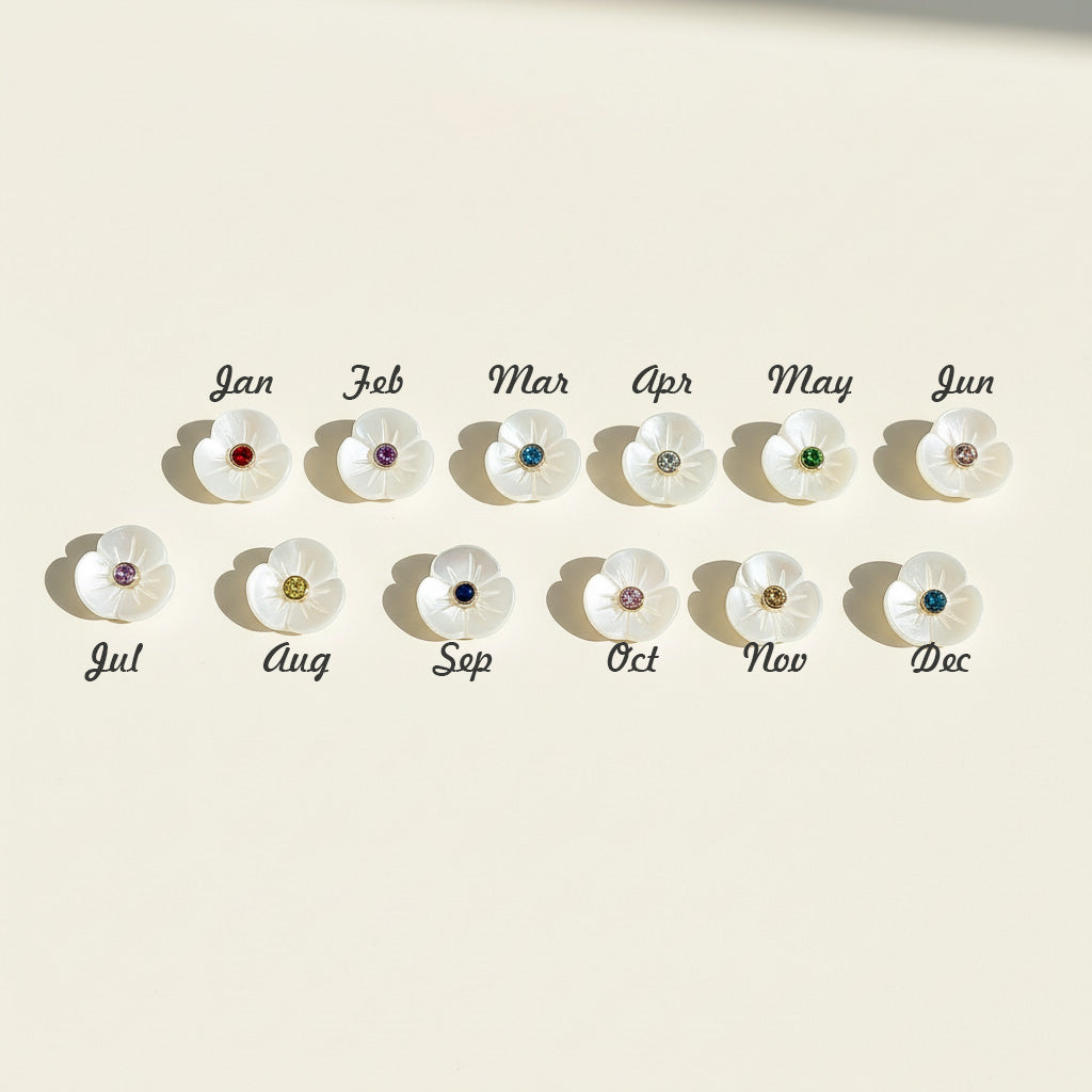 Twelve mother-of-pearl flower charms with cubic zirconia birthstones for each month from January to December.