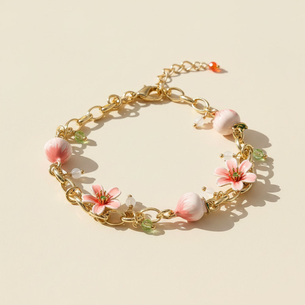 Gold bracelet with pink floral charms on a beige background