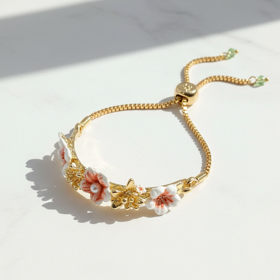 Gold bracelet with floral and butterfly designs on a light background