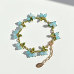 Aqua blue berry garden bracelet featuring round semi-precious stones and botanical enamel leaf accents