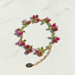 Bracelet with pink beads and gold chain on a white background