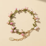 Bracelet with pink beads and gold chain on a beige background