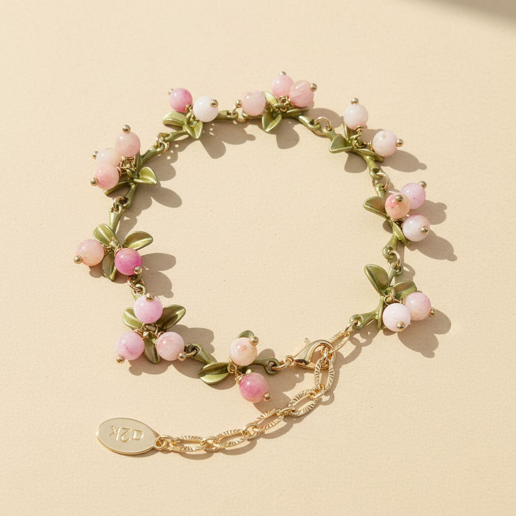 Bracelet with pink beads and gold chain on a beige background