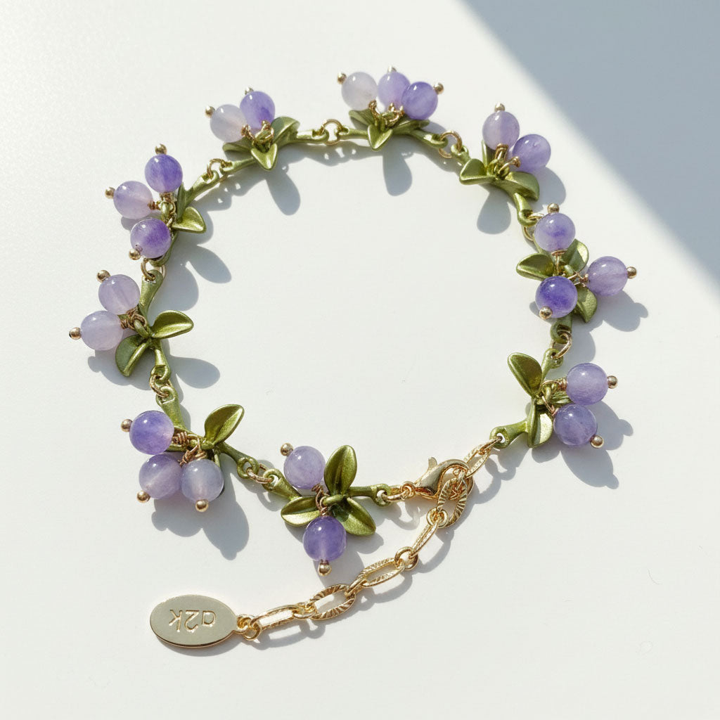 Bracelet with purple beads and gold chain on a light background