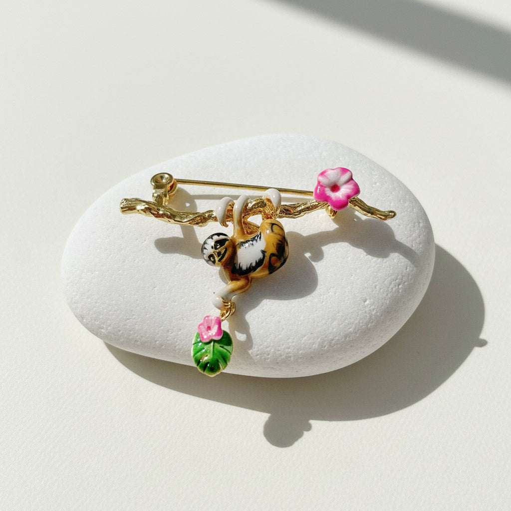 Decorative brooch with floral and animal print elements on a white stone surface