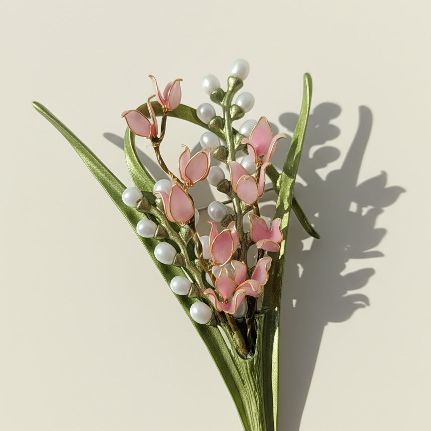 Close-up of hand-painted lily of the valley enamel flowers with pearl accents