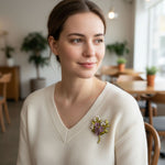 Model wearing handcrafted purple resin flower brooch on knit top
