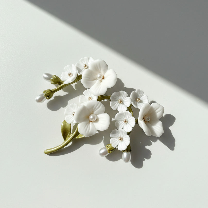 Porcelain flower brooch with white blossoms, enamel green leaves and freshwater pearl accents