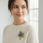 Model wearing handcrafted blue floral resin brooch on knit top