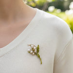 Lily of the valley floral brooch worn on knit top