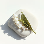 Handcrafted lily of the valley floral brooch with enamel leaves on white stone