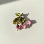 Hand-painted floral brooch with freshwater pearls on light background