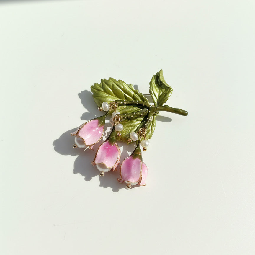 Botanical brooch with hand-painted petals and green leaves